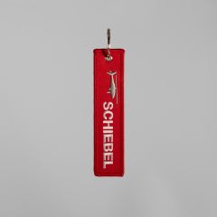 Vorderseite roter Schlüsselanhänger mit weißem Sticklogo "SCHIEBEL" und Drohne