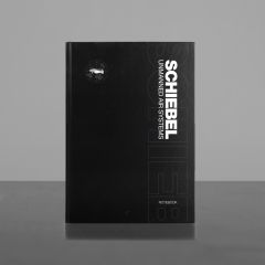 Schwarzes Notizbuch mit weißer Aufschrift "Schiebel Unmanned air systems", einer kleiner Drohne und Aufschrift "Notebook"