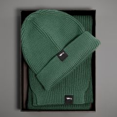 Opened cardboard packaging with green scarf and hat