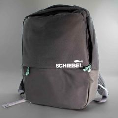Front of the black backpack, green cord on zippers, white “SCHIEBEL” logo with drone