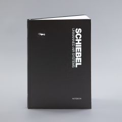 Black notebook with white lettering “Schiebel Unmanned air systems,” a small drone, and the word “Notebook.”